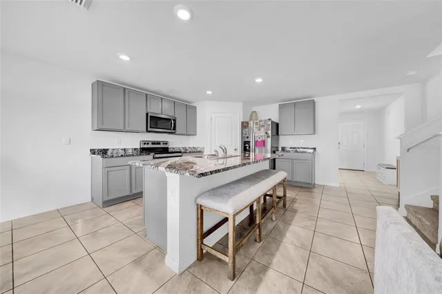 a kitchen with stainless steel appliances a stove a sink a microwave and a refrigerator