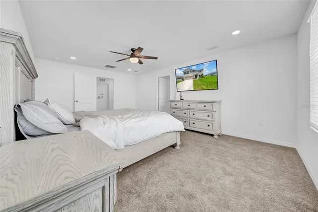 a bedroom with a bed and a ceiling fan