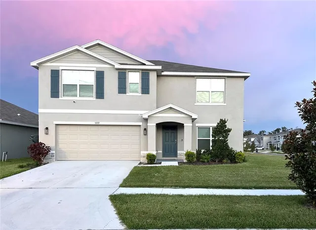 a front view of a house with a yard and garage