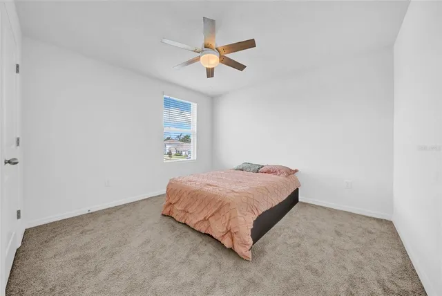a bedroom with a bed and a ceiling fan