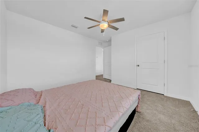 a bed room with a bed and a ceiling fan