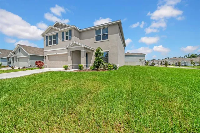 a front view of a house with a yard and garage
