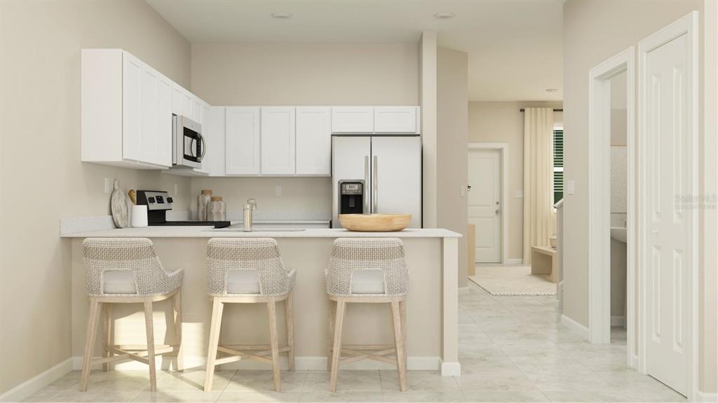 3088 Chromatic Street Kissimmee, FL 34758 - Photo 2 of 21 a kitchen with stainless steel appliances kitchen island granite countertop a table and chairs