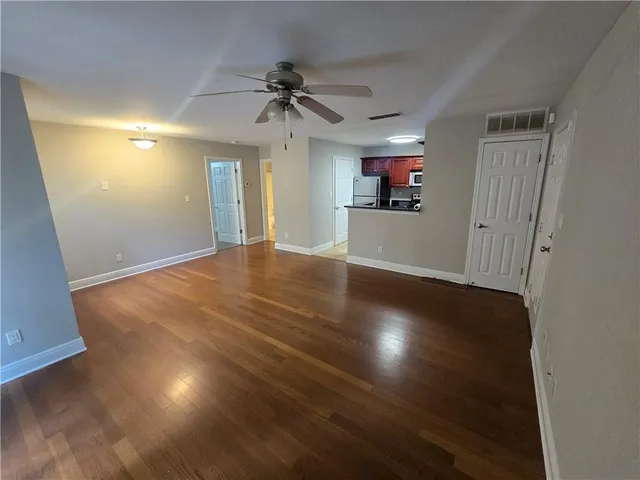 a view of empty room with wooden floor