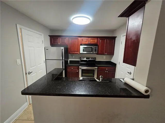 a kitchen with stainless steel appliances granite countertop a sink refrigerator and microwave
