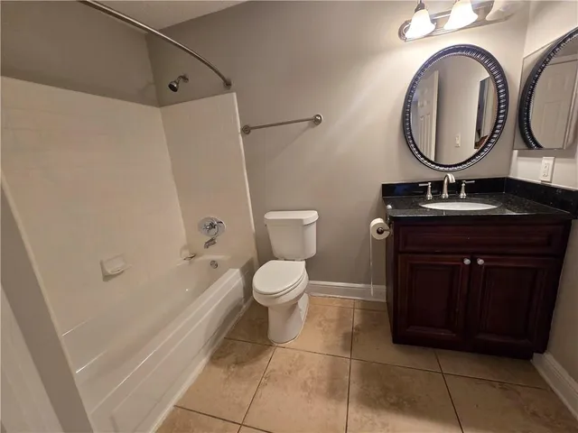 a bathroom with a toilet a mirror and bathtub