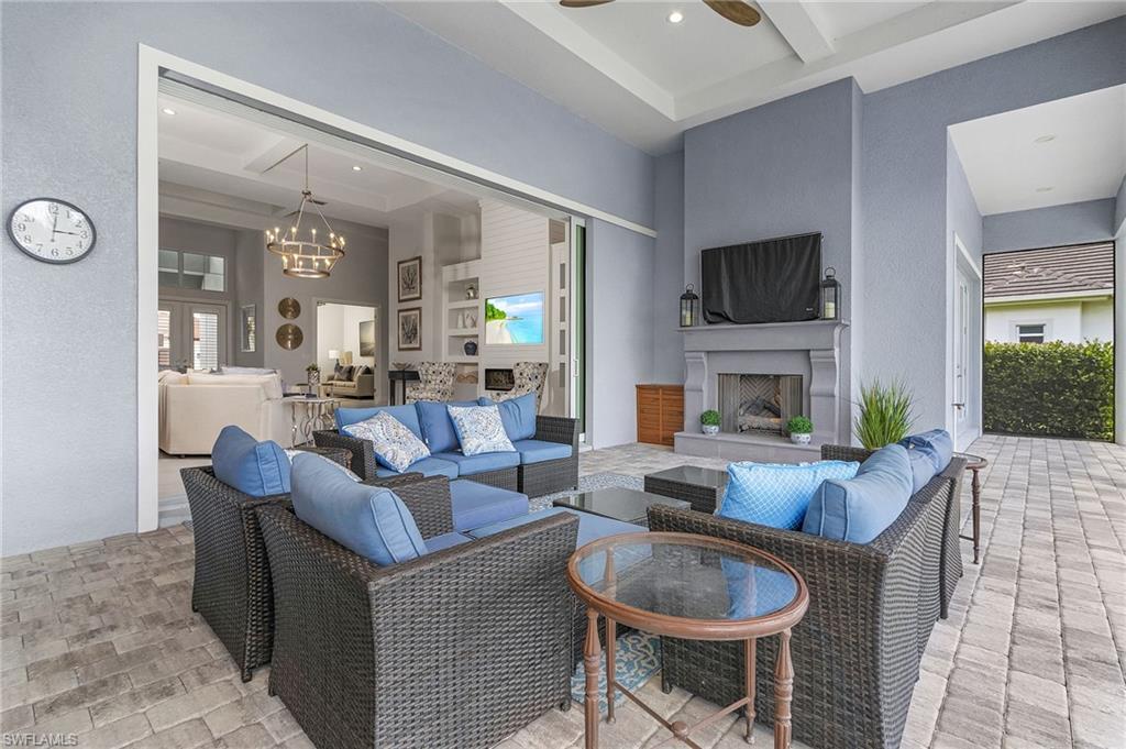 14226 Charthouse Circle Naples, FL 34114 - Photo 15 of 46 a living room with fireplace furniture and a flat screen tv