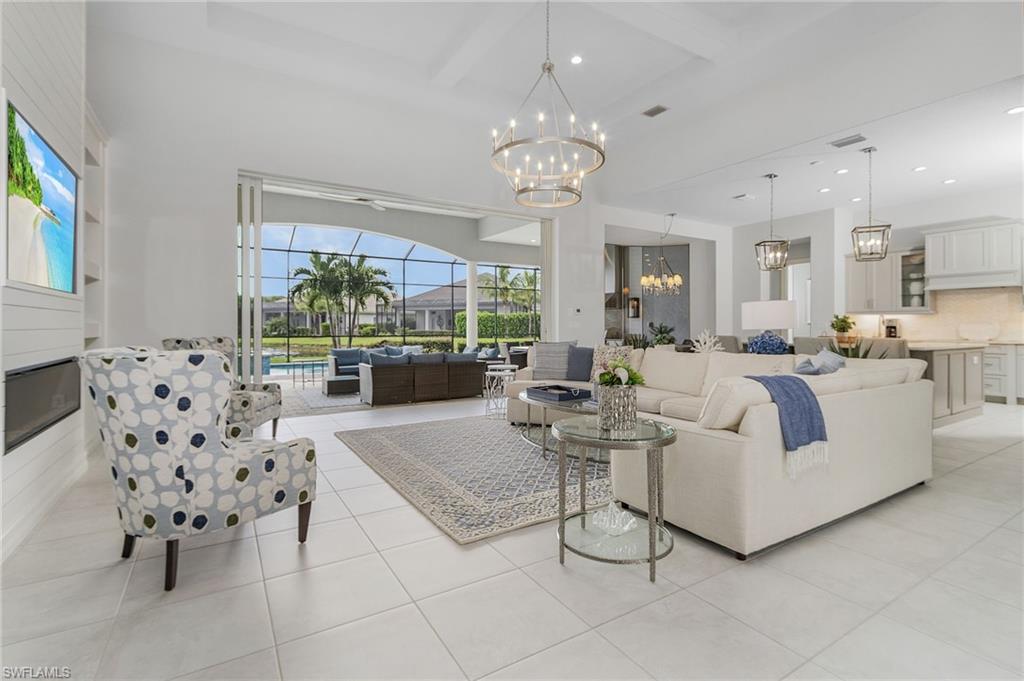 14226 Charthouse Circle Naples, FL 34114 - Photo 18 of 46 a living room with furniture a chandelier and a large window