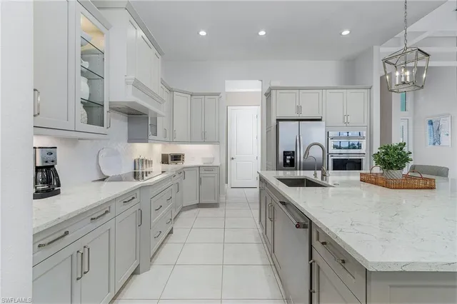 a kitchen with stainless steel appliances granite countertop a sink a center island a stove a table and chairs