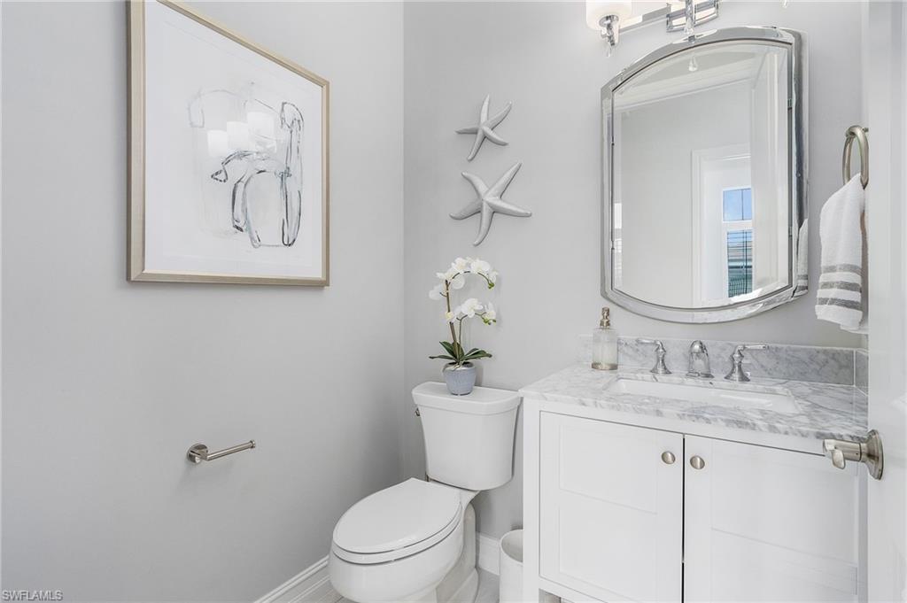 14226 Charthouse Circle Naples, FL 34114 - Photo 25 of 46 a bathroom with a toilet sink and mirror