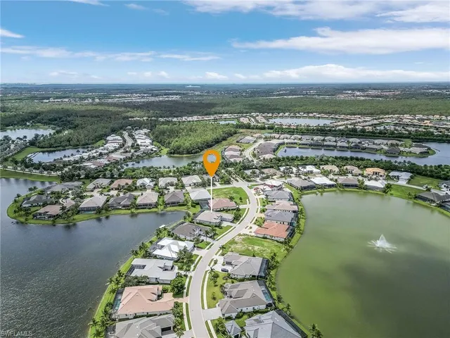 an aerial view of ocean and residential houses with outdoor space