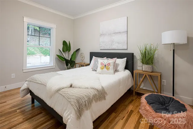 a bedroom with a bed flowerpot and window