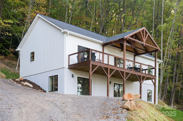 a view of a house with a yard and wooden deck