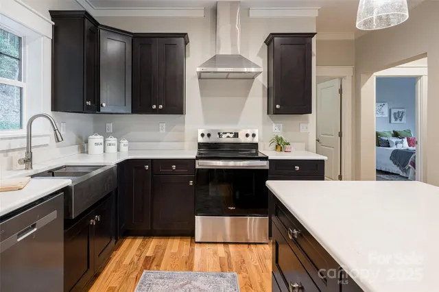 a kitchen with a sink and a stove top oven with wooden floor