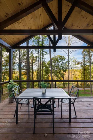 a view of a patio with table and chairs under an umbrella with a small yard