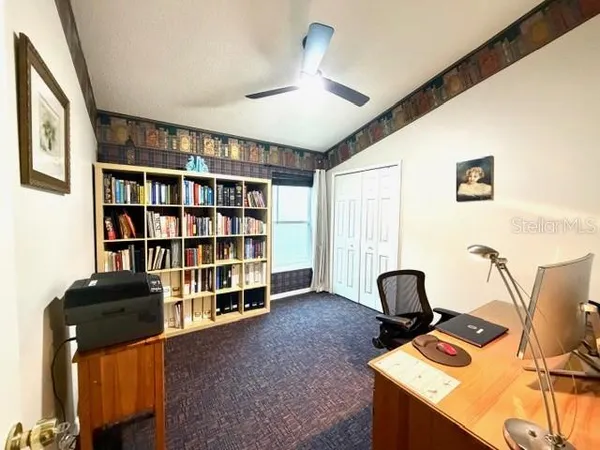 a view of a workspace with furniture and a bookshelf
