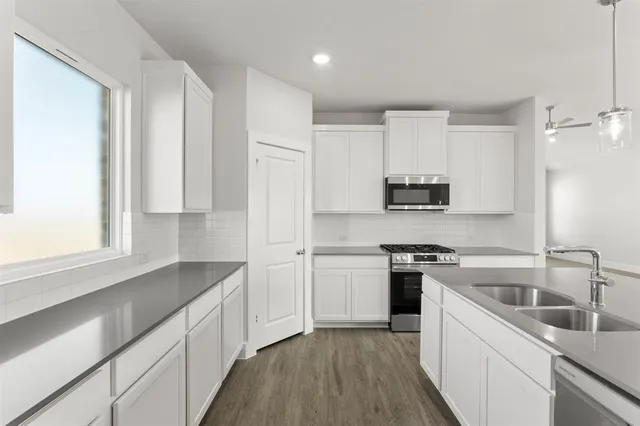 a kitchen with granite countertop white cabinets and white appliances