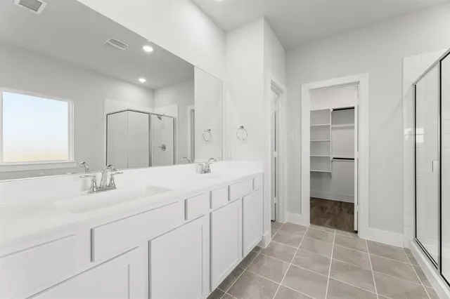 a spacious bathroom with a double vanity sink and a mirror