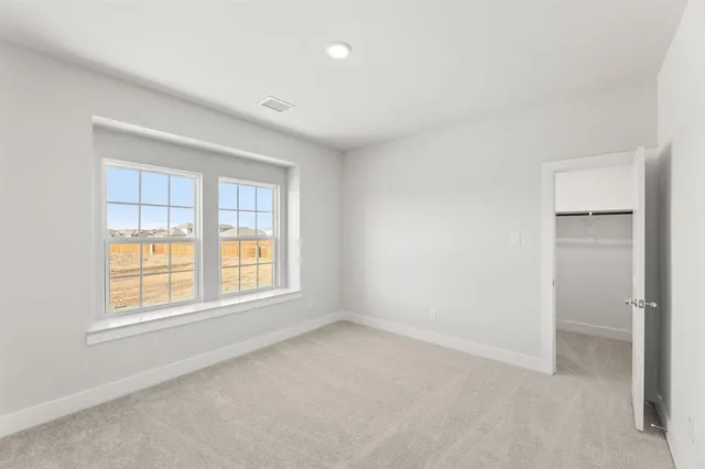 an empty room with windows and closet