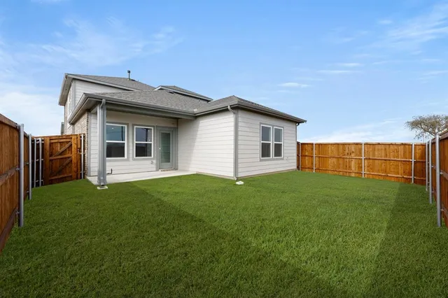 a view of a backyard with plants and large tree
