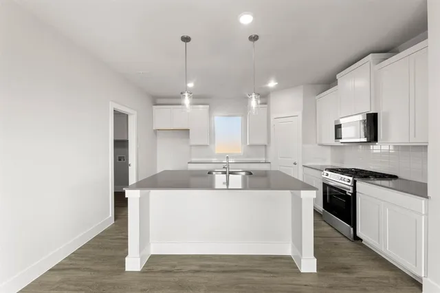 a large kitchen with a center island and stainless steel appliances