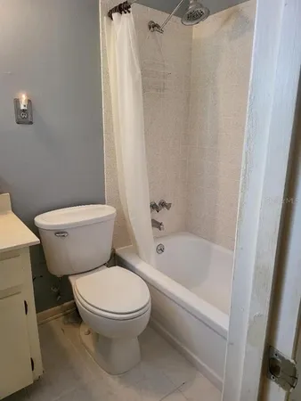 a white toilet sitting next to a bath tub