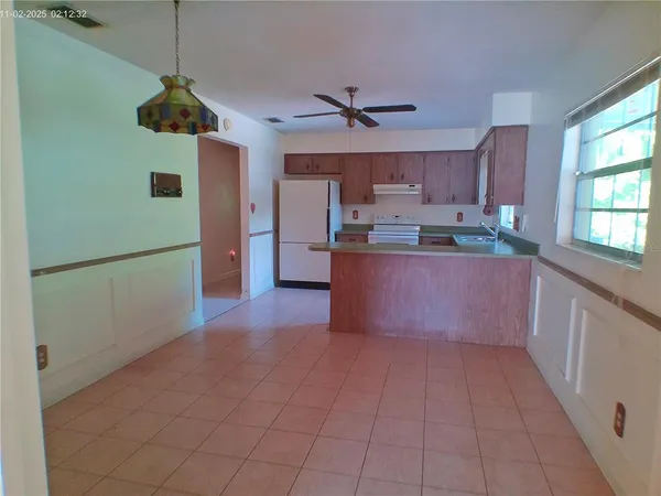 a kitchen with stainless steel appliances granite countertop a refrigerator a sink a stove and a wooden floors