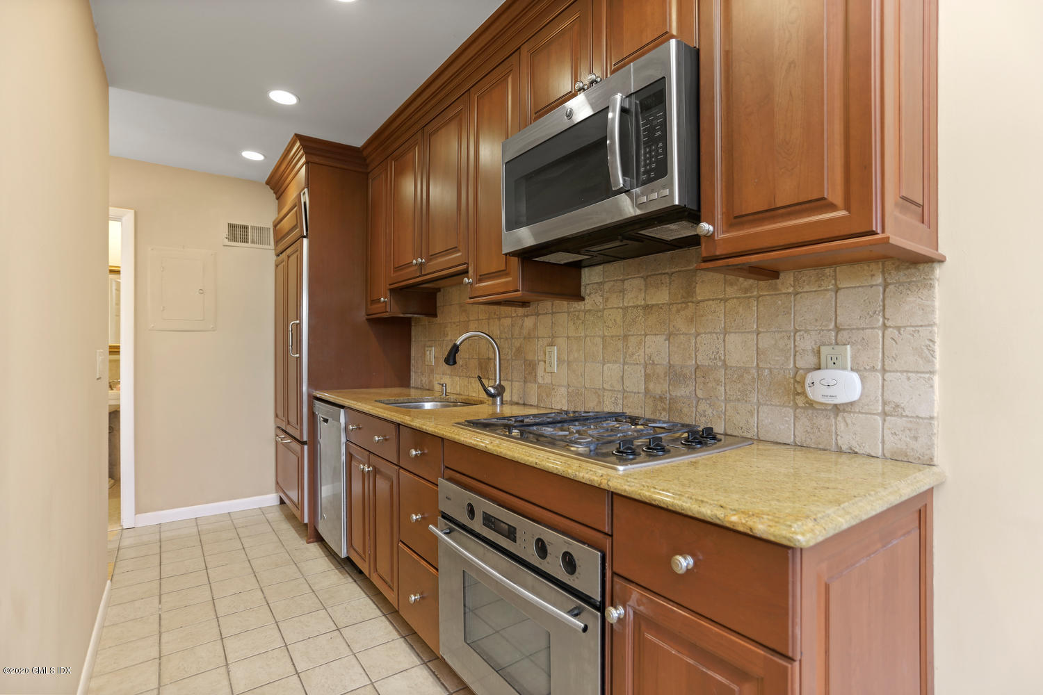 19 Whiffletree Way, Unit 19 Riverside, CT 06878 - Photo 9 of 32 a kitchen with stainless steel appliances granite countertop a stove a microwave and a refrigerator
