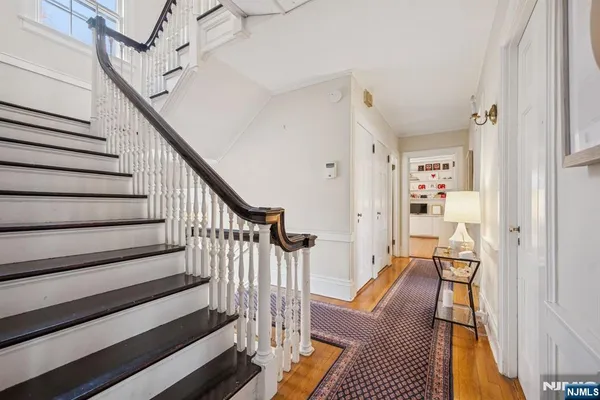 a view of a hallway with wooden floor and staircase