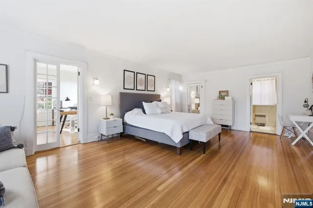a spacious bedroom with a bed and wooden floor