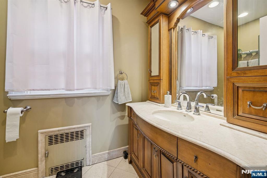 258 Ridgewood Avenue Glen Ridge, NJ 07028 - Photo 23 of 44 a bathroom with a sink and a mirror