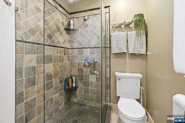 a white toilet sitting next to a shower