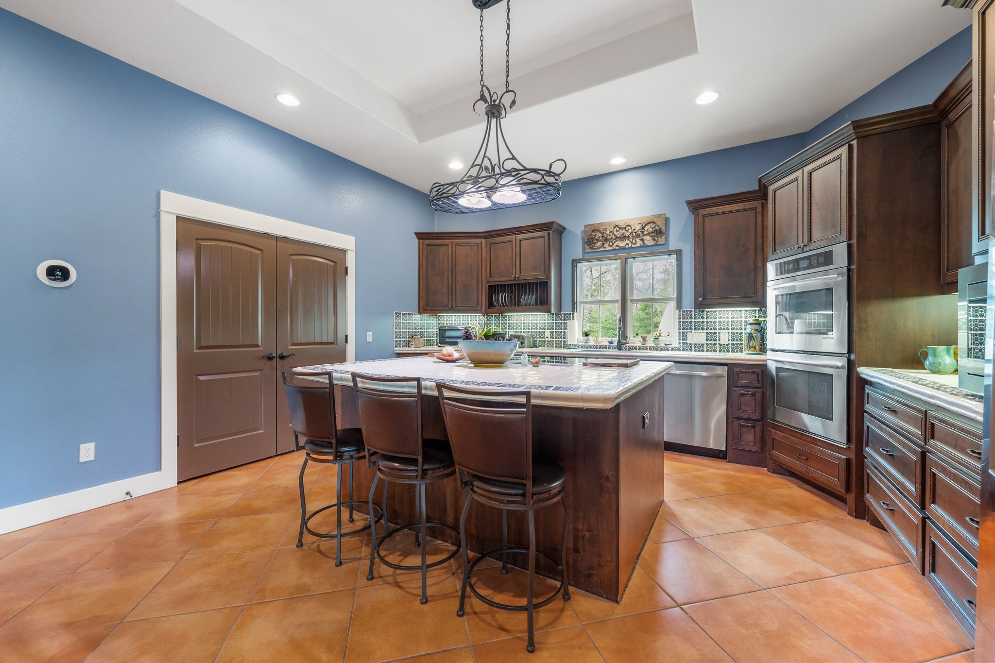 129 Painted Post Bastrop, TX 78602 - Photo 16 of 40 The kitchen comes ready to use with custom cabinetry and an entertainers island complete with bar seating, chandelier lighting, and decorative tiled countertops.