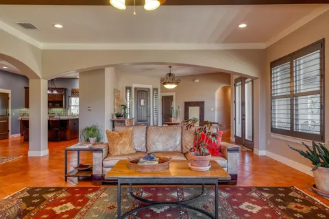 a living room with furniture and a dining table with wooden floor