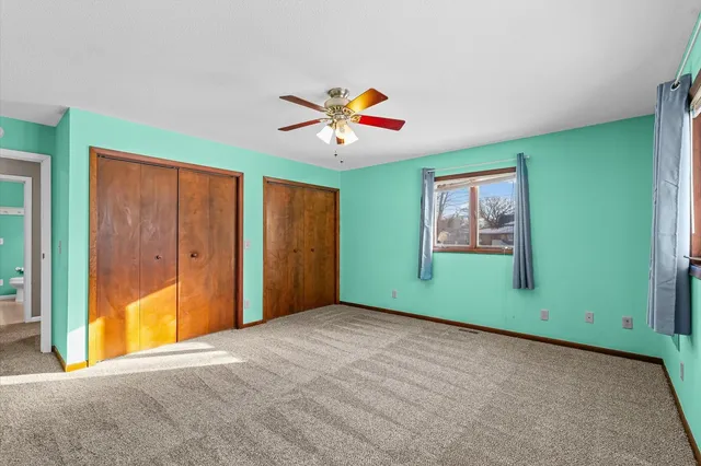 an empty room with window and ceiling fan