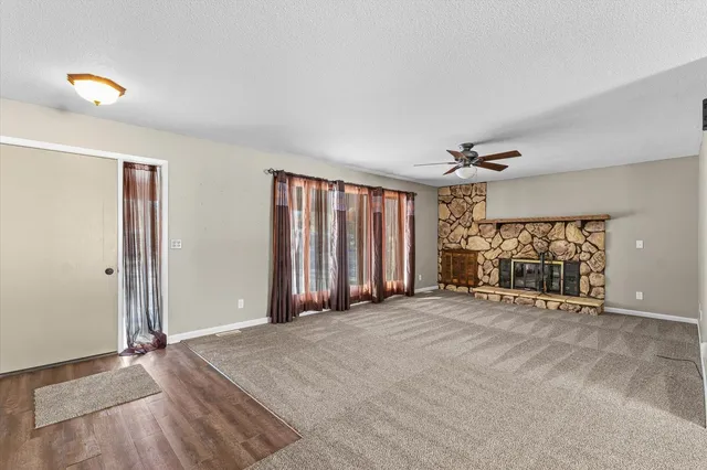 a view of an empty room with a window and a livingroom