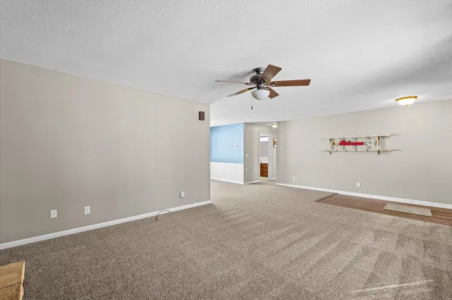 a view of a livingroom with a ceiling fan and window