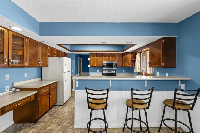 a kitchen with stainless steel appliances granite countertop a stove a sink and a refrigerator