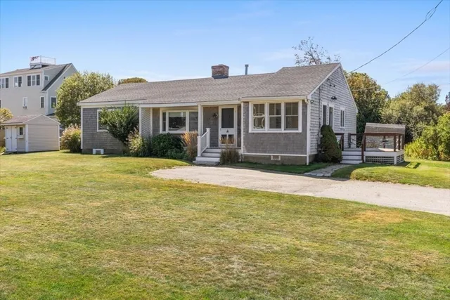 a front view of house with yard and trees in the background