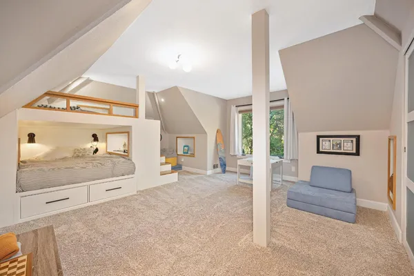 a bedroom with a bed and a dresser with mirror