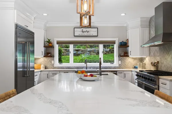 a kitchen with stainless steel appliances granite countertop a stove a sink and a refrigerator