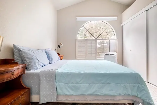 a bedroom with a bed and a large window