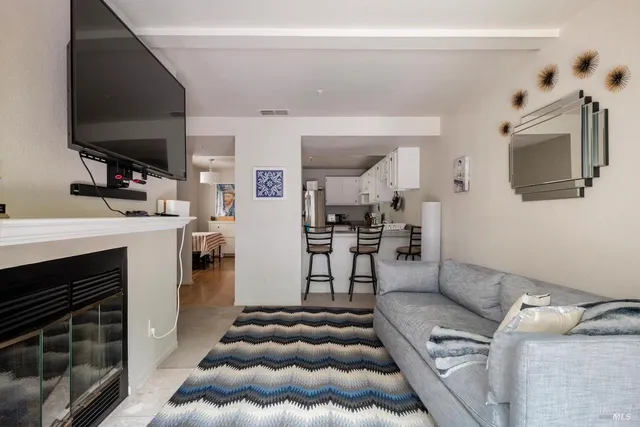 a living room with furniture a flat screen tv and kitchen view