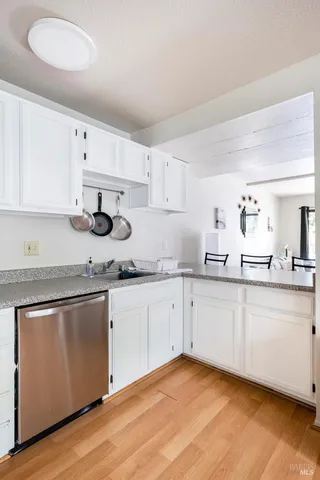 a kitchen with granite countertop cabinets stainless steel appliances and a sink