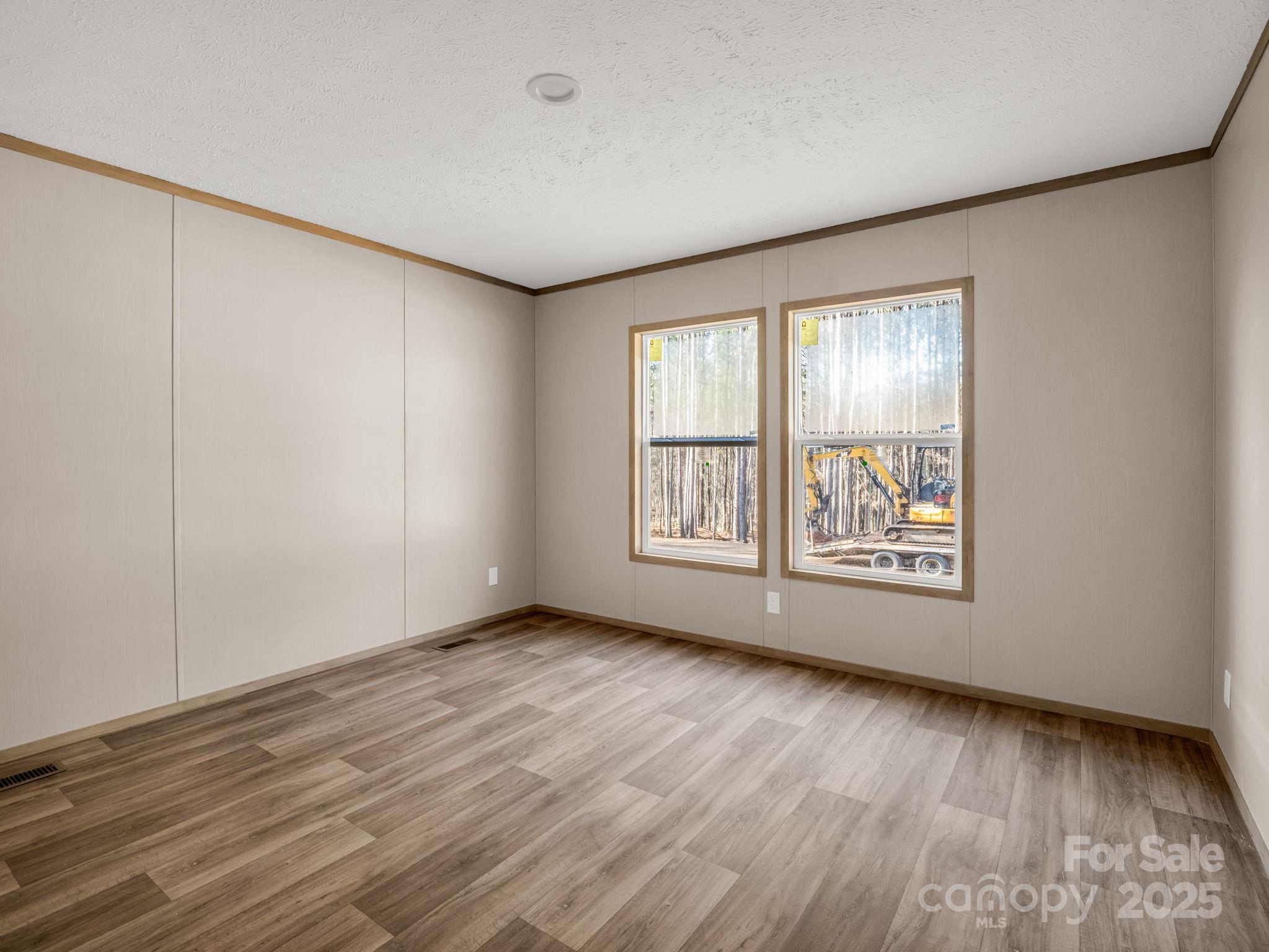 864 Tiney Road Ellenboro, NC 28040 - Photo 21 of 33 an empty room with wooden floor and windows