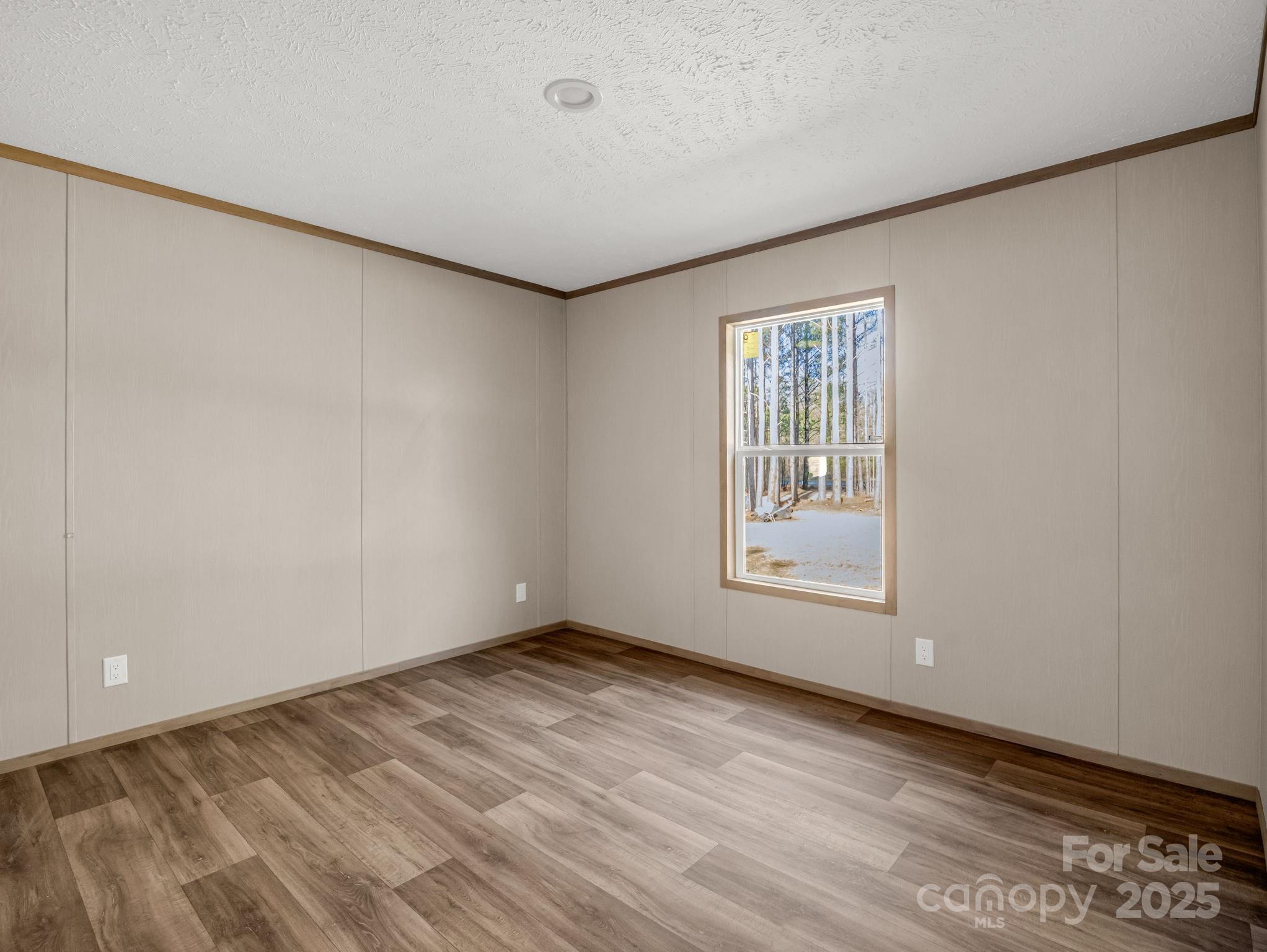 864 Tiney Road Ellenboro, NC 28040 - Photo 23 of 33 a view of an empty room with wooden floor and a window