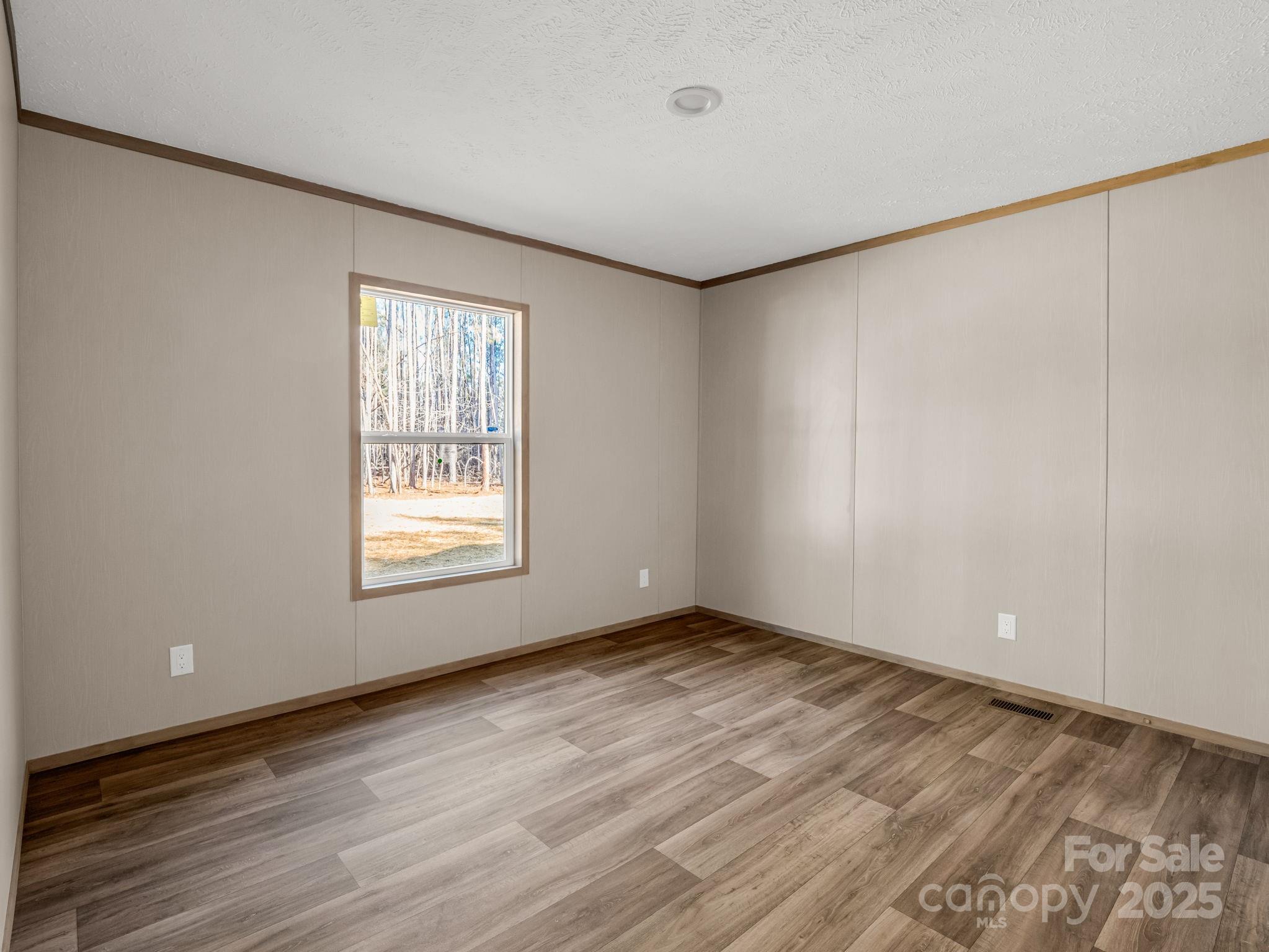 864 Tiney Road Ellenboro, NC 28040 - Photo 25 of 33 a view of an empty room with wooden floor and a window