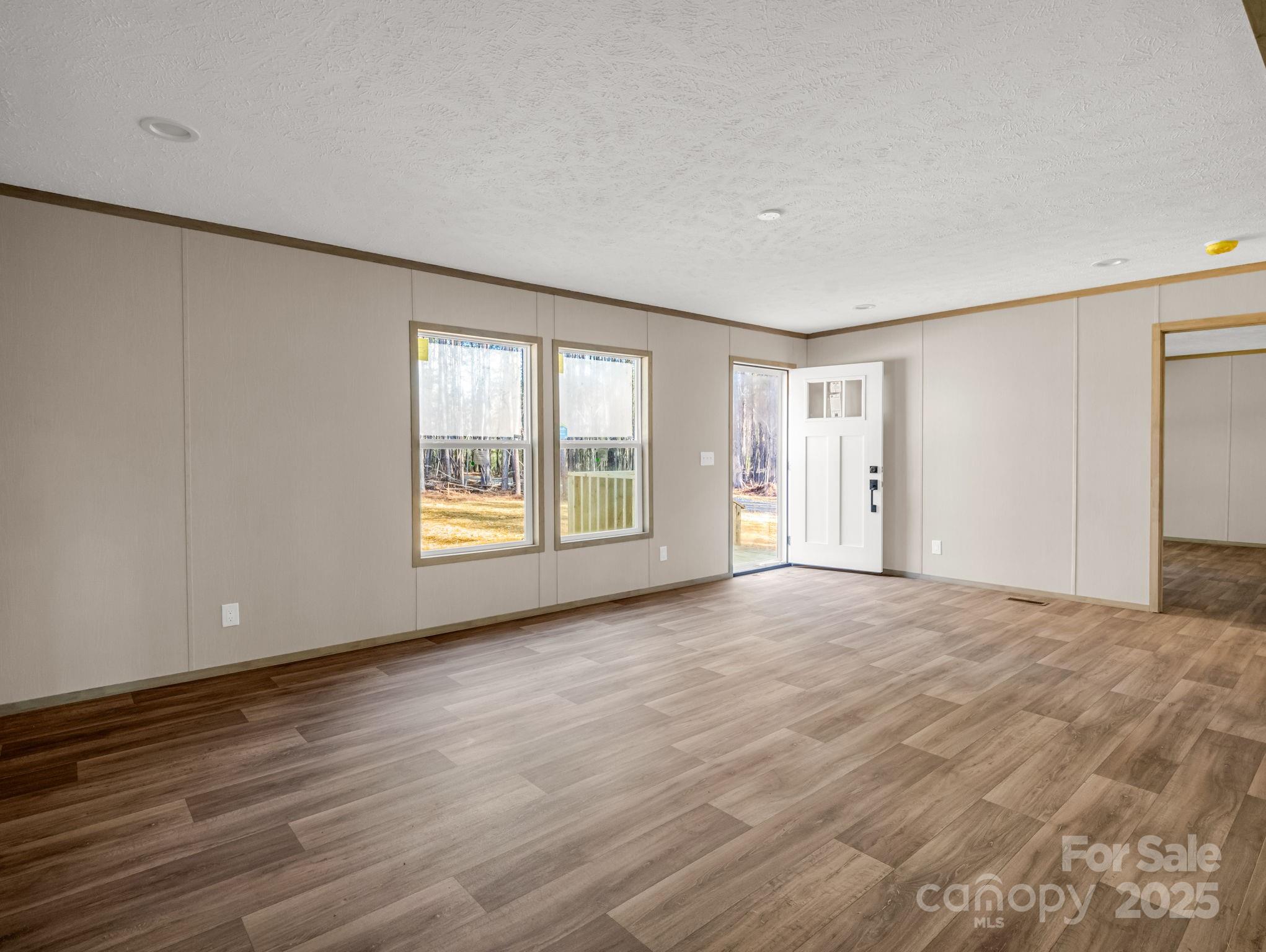 864 Tiney Road Ellenboro, NC 28040 - Photo 7 of 33 a view of an empty room with wooden floor and a window