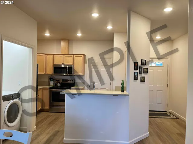 a kitchen with stainless steel appliances granite countertop a refrigerator stove and microwave