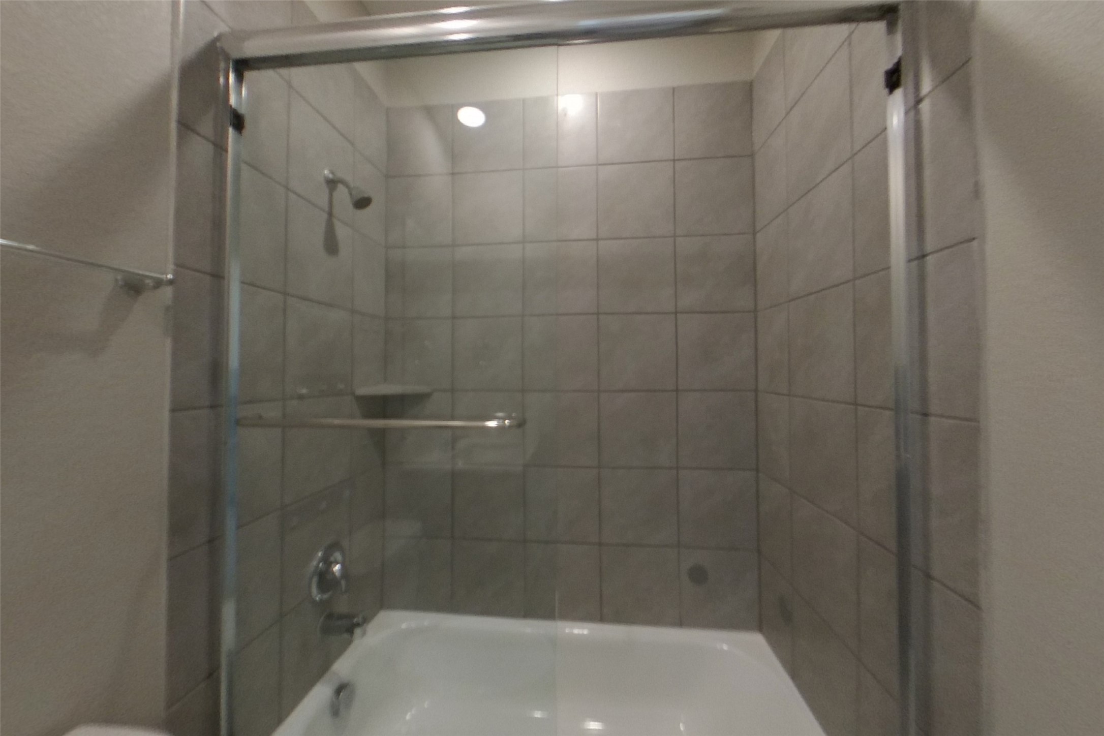 508 Raglands Road Leander, TX 78641 - Photo 15 of 18 A glass-enclosed tub features neat tile surrounds and polished silver hardware.